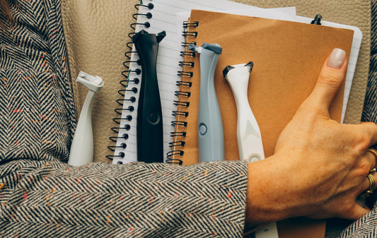Woman holding notebooks and four Slate Origin electric flossers