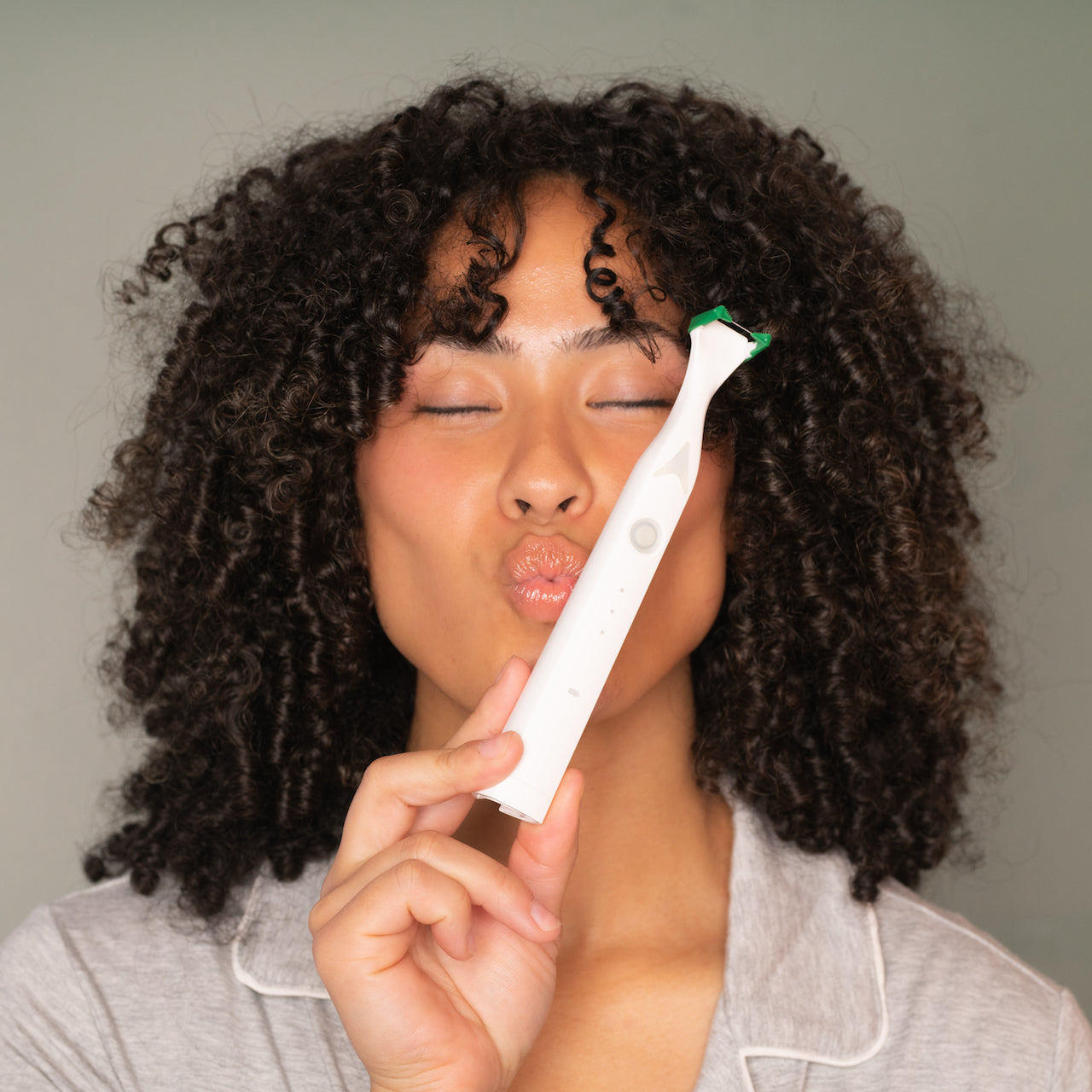 Model holding Slate Electric flosser.