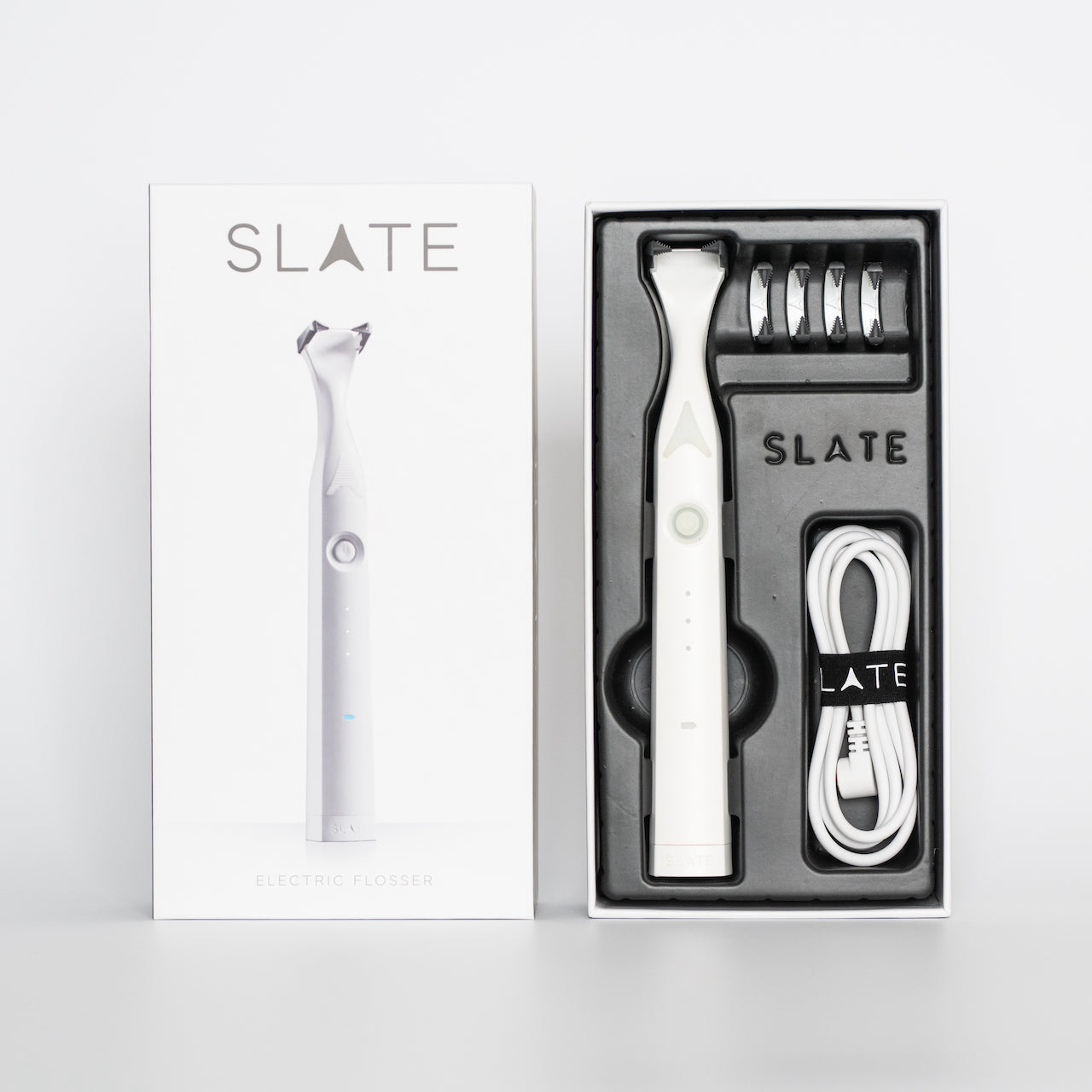 Slate Rechargeable Flosser in packaging. Contains flosser, four floss heads, and charging cable.